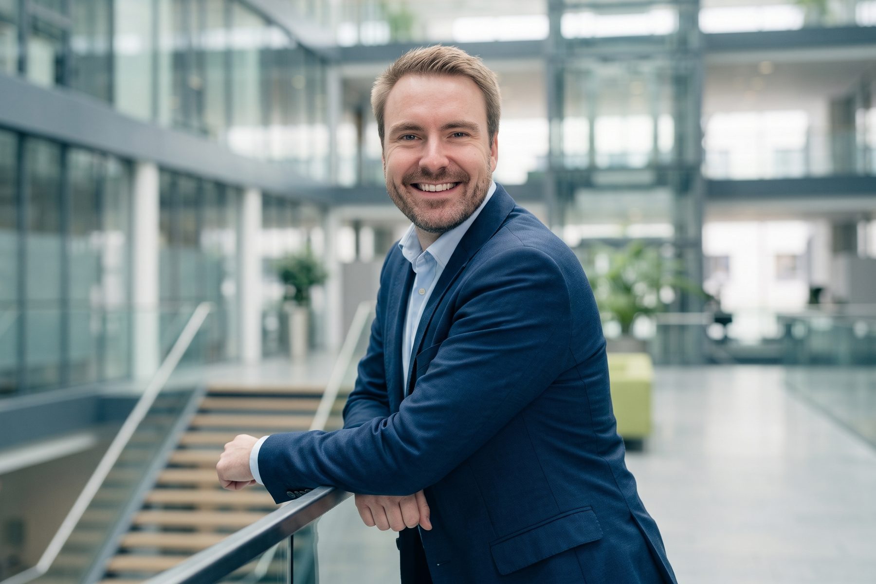 Marius Pfeiffer an einem Geländer in einem hellen Atrium